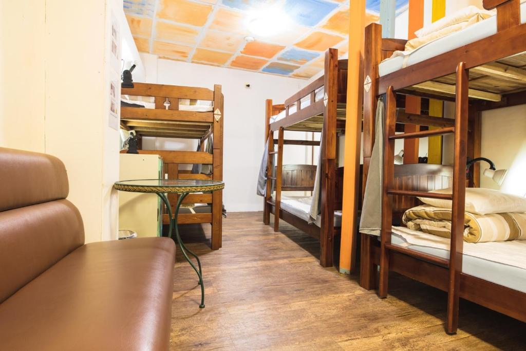 a room with three bunk beds and a table at On My Way Jiufen Youth Hostel in Jiufen