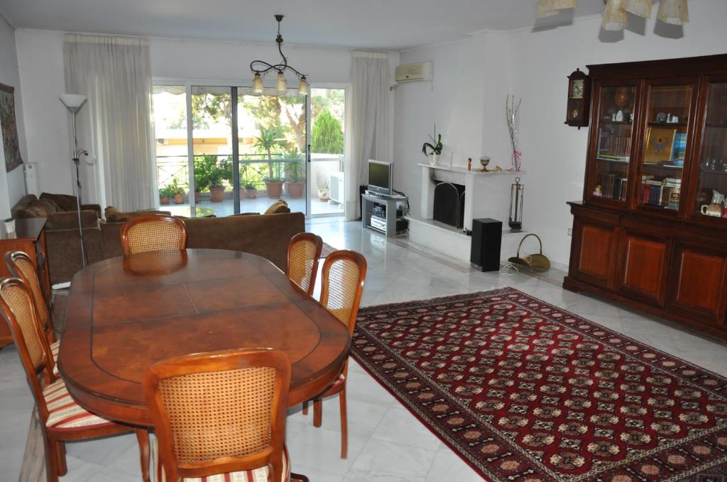 uma mesa de jantar e cadeiras numa sala de estar em 145 м2 Seaside Apartment em Atenas