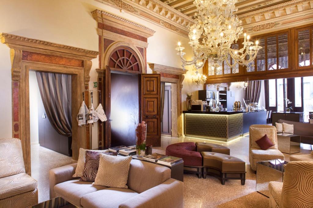 sala de estar con muebles y lámpara de araña. en Arcadia Boutique Hotel en Venecia