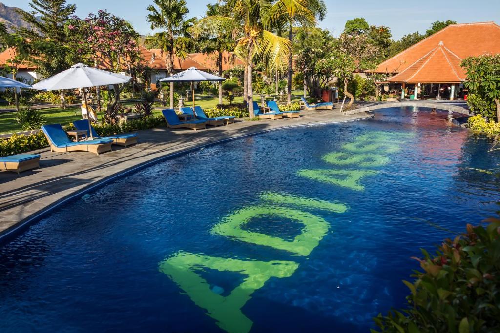 a swimming pool with the word debt in the water at Adi Assri Beach Resorts And Spa Pemuteran in Pemuteran