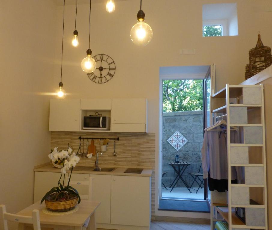una cucina con mobili bianchi e tavolo di Recondita Armonia a Sorrento