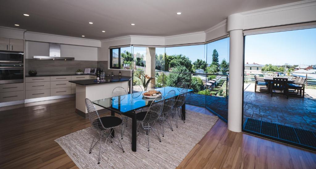 a kitchen with a table with chairs and a large window at Russell House in Hobart