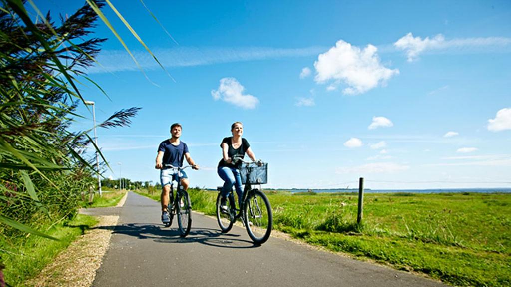 un hombre y una mujer montando bicicletas por un camino en Bed & Breakfast Sirius, en Glud