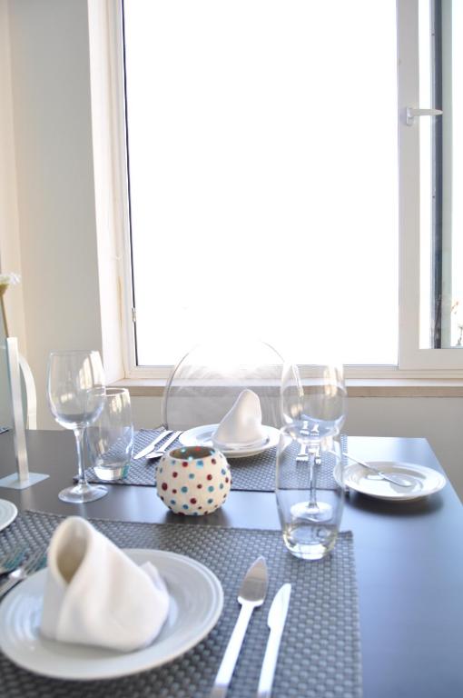 a table with white plates and silverware on it at Hotel Mar Bravo in Nazaré