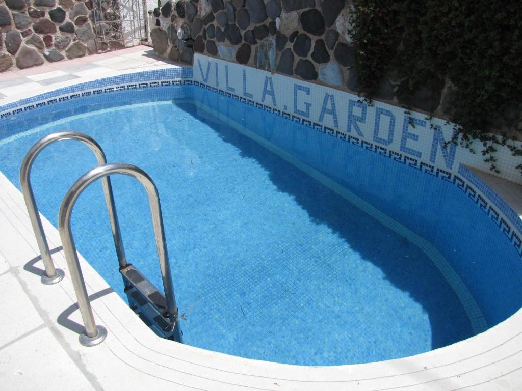 - une grande piscine d'eau bleue dans un complexe dans l'établissement Villa Garden, à Fira
