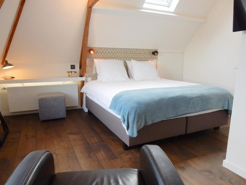 een slaapkamer met een bed, een bureau en stoelen bij Boutique B&B Nassau in Amsterdam