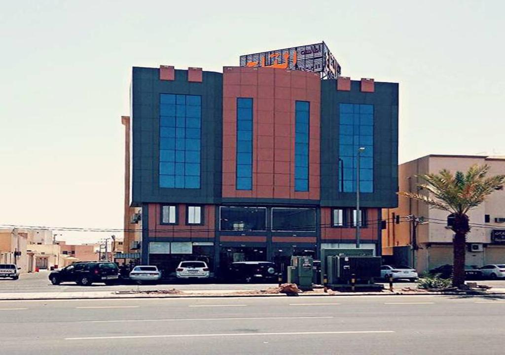 a building on the side of a street with a parking lot at Almasah Altaj Aparthotel in Hail