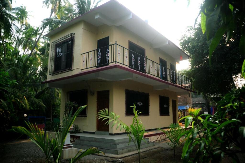 a house with a balcony on top of it at Sai Sneh Holidays Cottage in Alibaug
