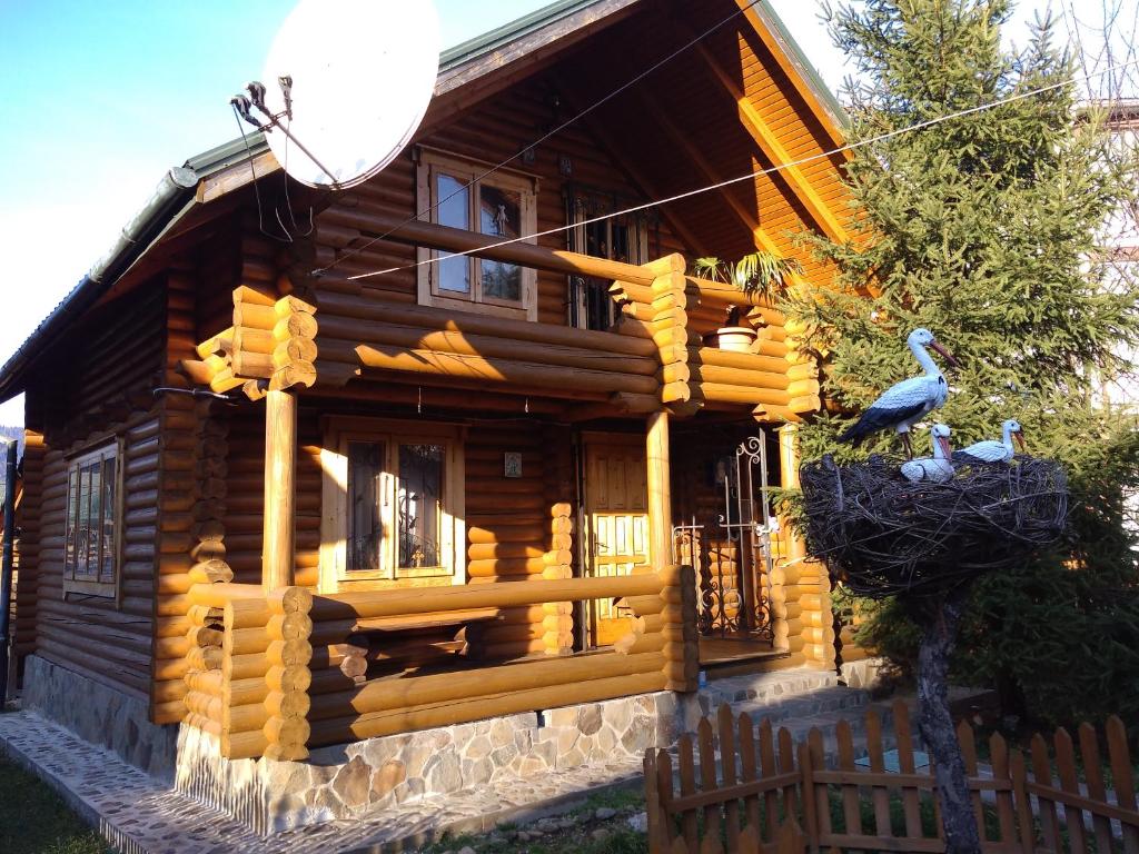 a log cabin with two birds on the front of it at Teremok in Tatariv