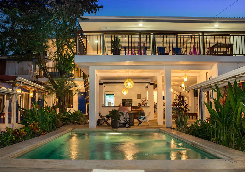 una casa con piscina frente a ella en Hostel La Botella de Leche - Tamarindo en Tamarindo