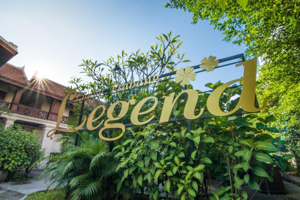 un panneau indiquant un hôtel devant un bâtiment dans l'établissement Luang Prabang Legend Hotel, à Luang Prabang