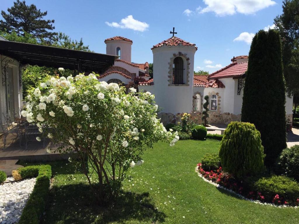 マダラにあるVilla St. Michaelの白い花の家の前の庭