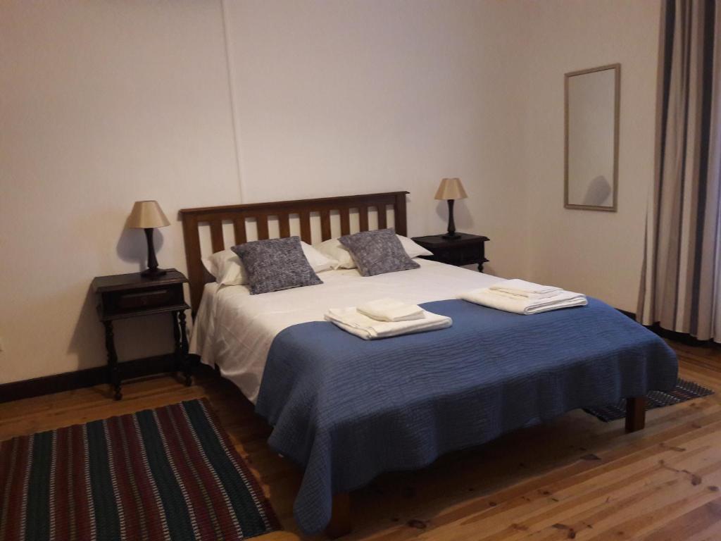 ein Schlafzimmer mit einem Bett mit zwei Handtüchern darauf in der Unterkunft Casa do Beco do Beiçudo centro de Evora in Évora