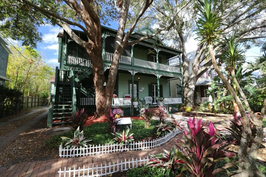 een groen huis met een boom ervoor bij Historic Sevilla House (Adults only) in St. Augustine