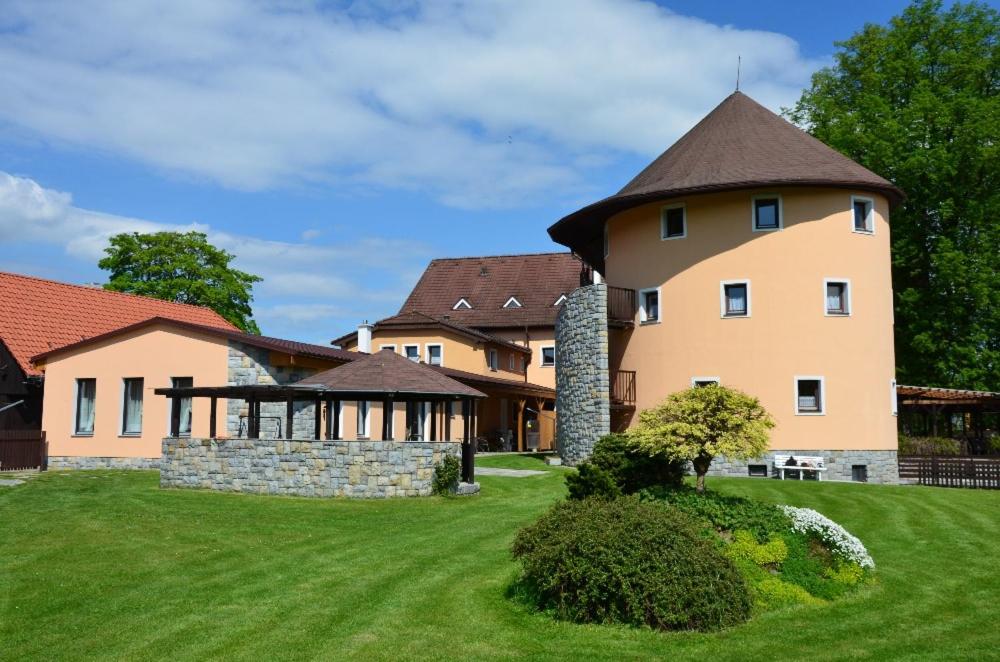 ein großes Haus mit einem Turm auf einem grünen Rasen in der Unterkunft Penzion Marie - Žumberk in Žumberk