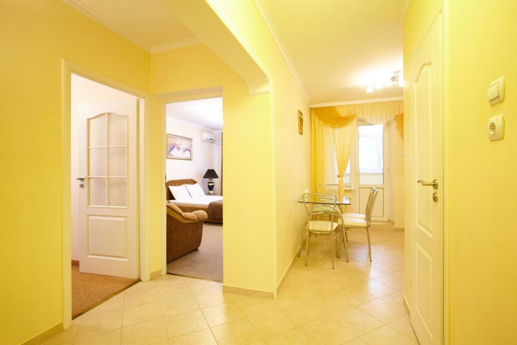 - un couloir avec une chambre dotée d'un lit et d'une table dans l'établissement Apartment Deluxe on Moscow Avenue, à Chişinău