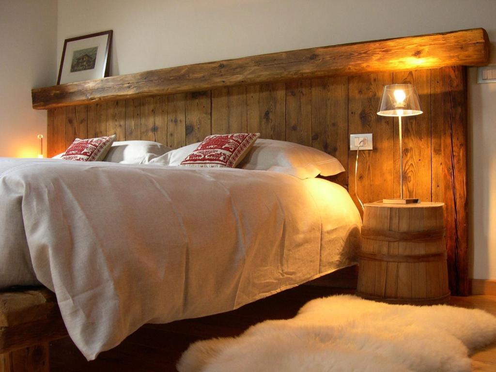 una camera con un grande letto con testiera in legno di Tre Alberi Liberi ad Alagna Valsesia