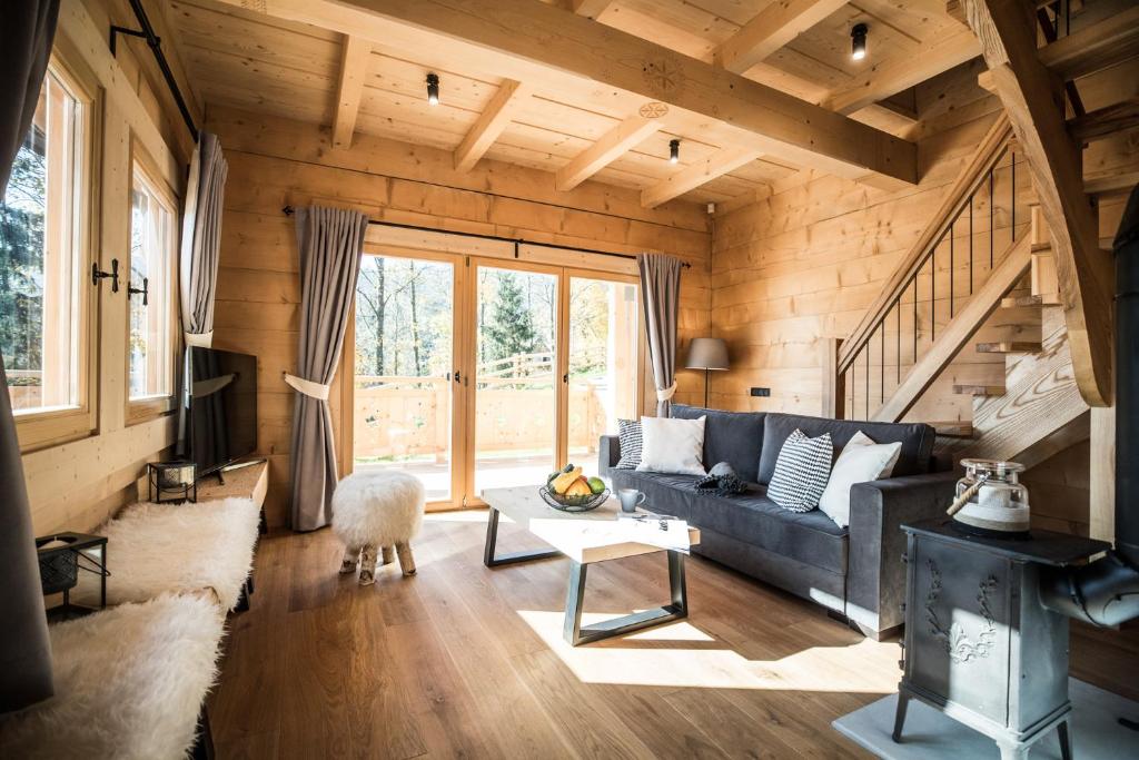 a living room with a blue couch and wooden walls at Osada domków TATRA-DREAM in Zakopane