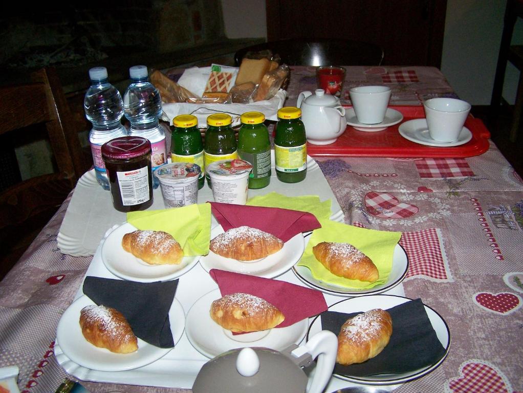 una mesa con platos de comida y bebidas. en b&b da Maria, en Fagagna