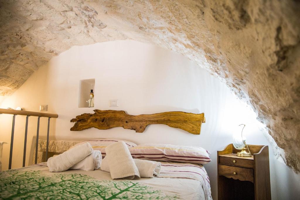 ein Schlafzimmer mit einem Bett mit einem Holzscheit an der Wand in der Unterkunft Il Nido Bianco in Ostuni
