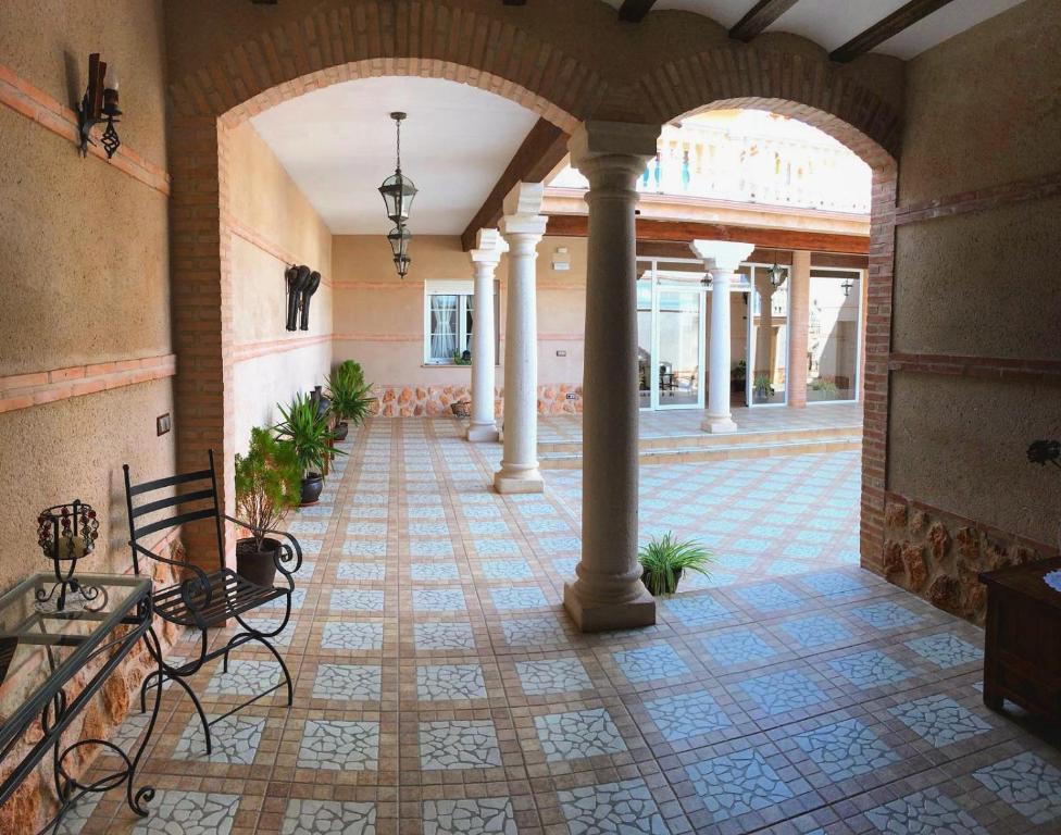 an empty hallway with columns and a tile floor at Casa Rural La Toza de Avelino in Almagro