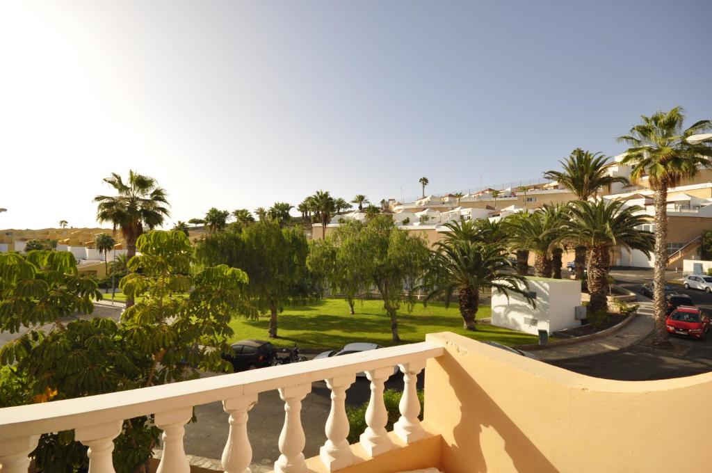 a balcony with a view of a street and palm trees at Paradise Court Las Americas WiFi Pool 25 in Adeje