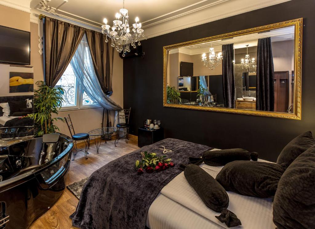 1 dormitorio con cama y espejo en Ben Akiba Luxury Suites, en Belgrado