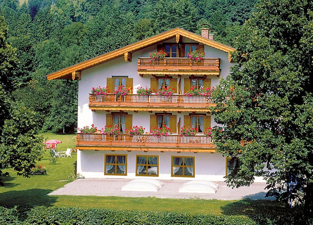 a house with a balcony with flowers on it at Gästehaus Pfatischer Hotel Fewo in Rottach-Egern