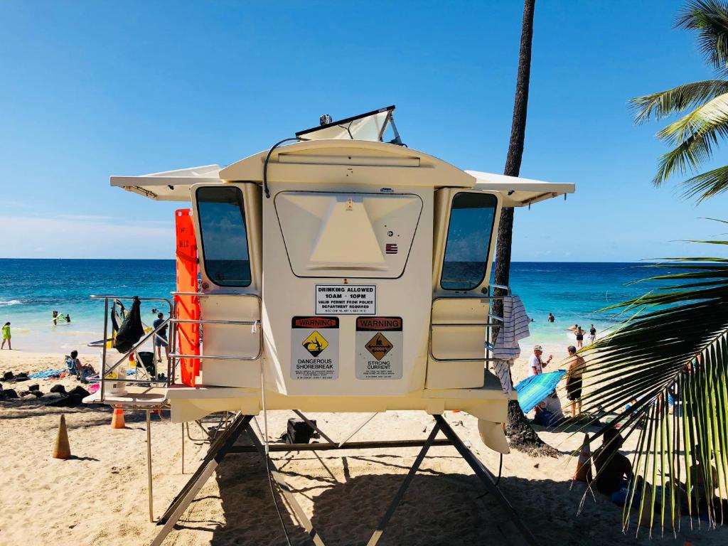 a camper van parked on a beach with people at Kona Magic Honu Room in Kailua-Kona