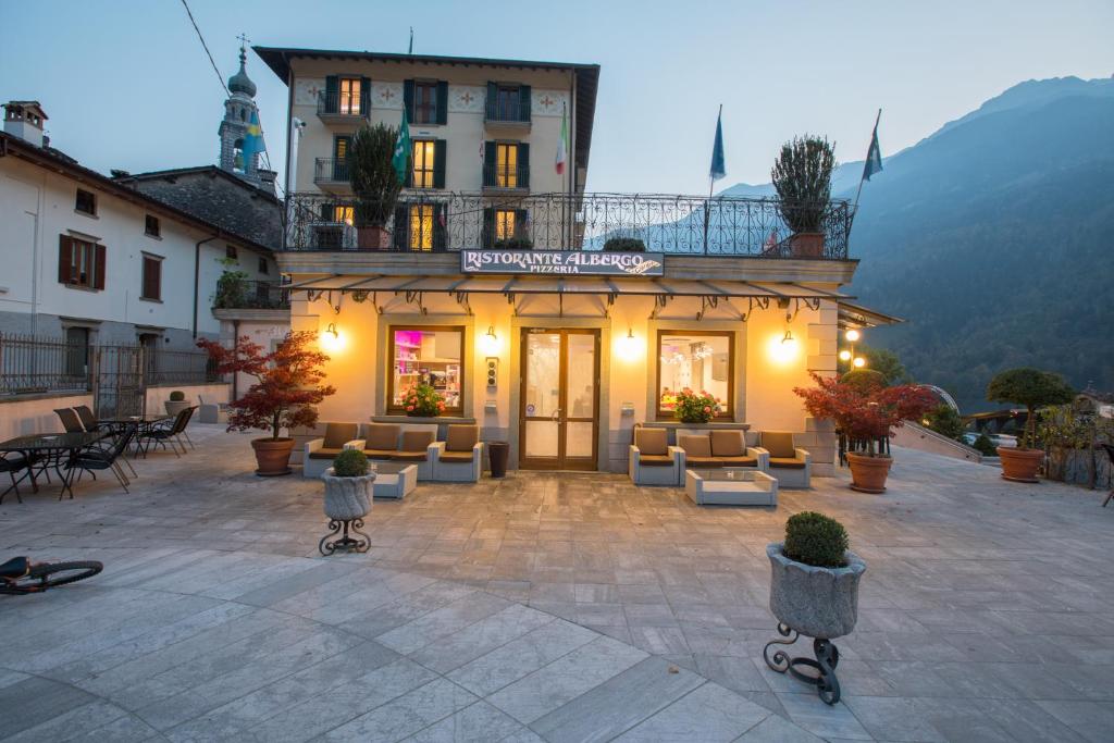 een gebouw met banken en stoelen op een binnenplaats bij Albergo Ardesio Da Giorgio in Ardesio