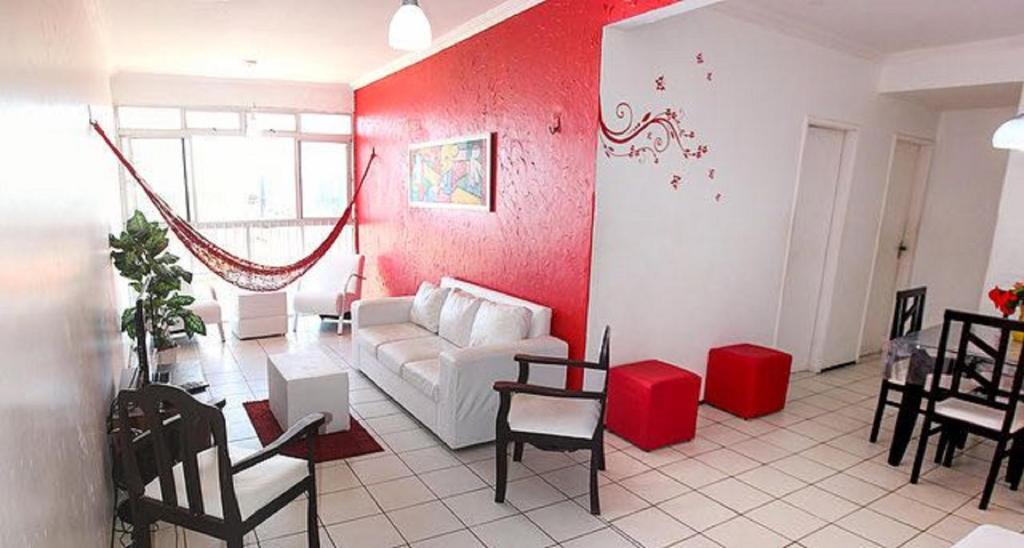 sala de estar con sofá blanco y pared roja en Apartamento Mobiliado AptCE, en Fortaleza