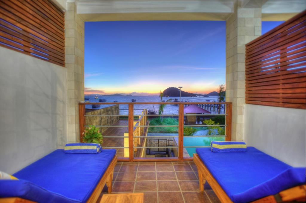 a balcony with two beds and a view of the ocean at Blue Marlin Dive Komodo in Labuan Bajo