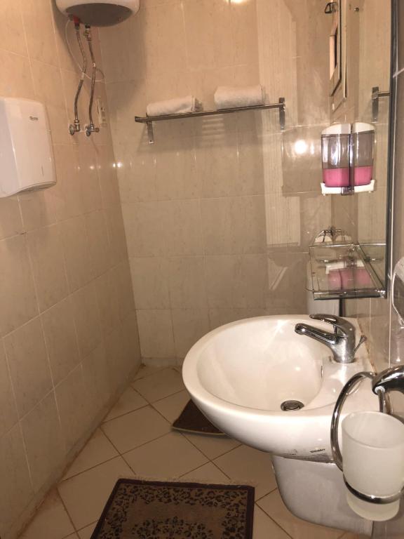 a bathroom with a white sink and a toilet at Chalet Porto South Beach - Beach Front Sea View in Ain Sokhna