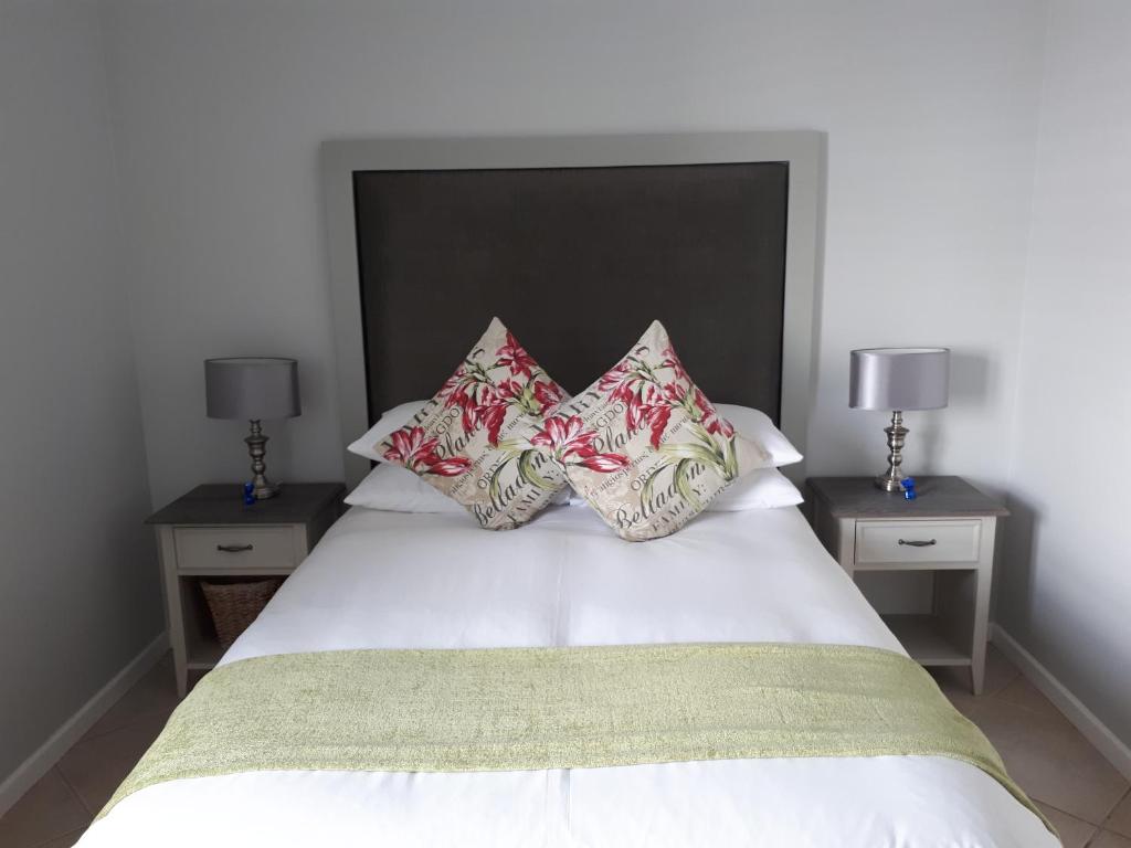ein Schlafzimmer mit einem weißen Bett mit vier Kissen in der Unterkunft 51 Trafford in George