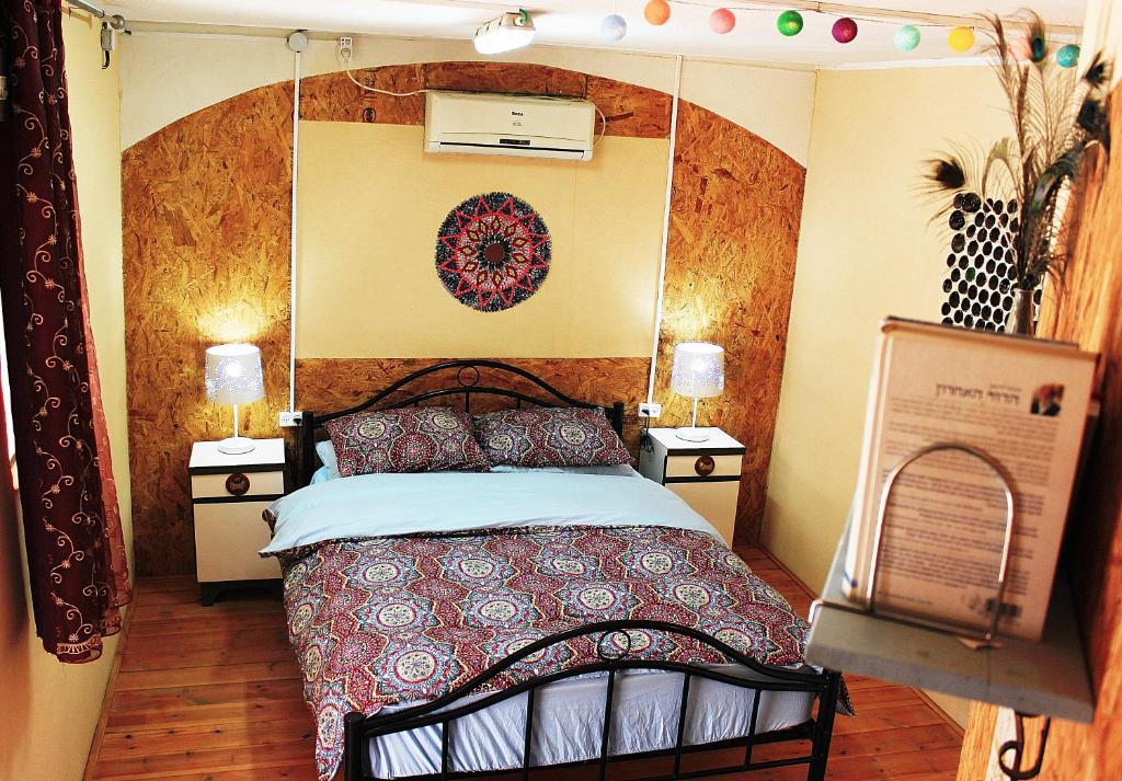 ein Schlafzimmer mit einem Bett und zwei Nachttischen in der Unterkunft Chen in Ezuz in ‘Ezuz