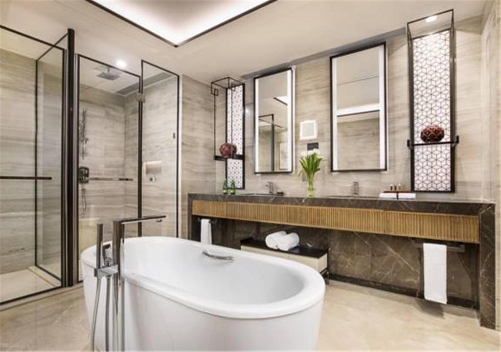 a large bathroom with a tub and a shower at Ascott Riverside Garden Beijing in Beijing