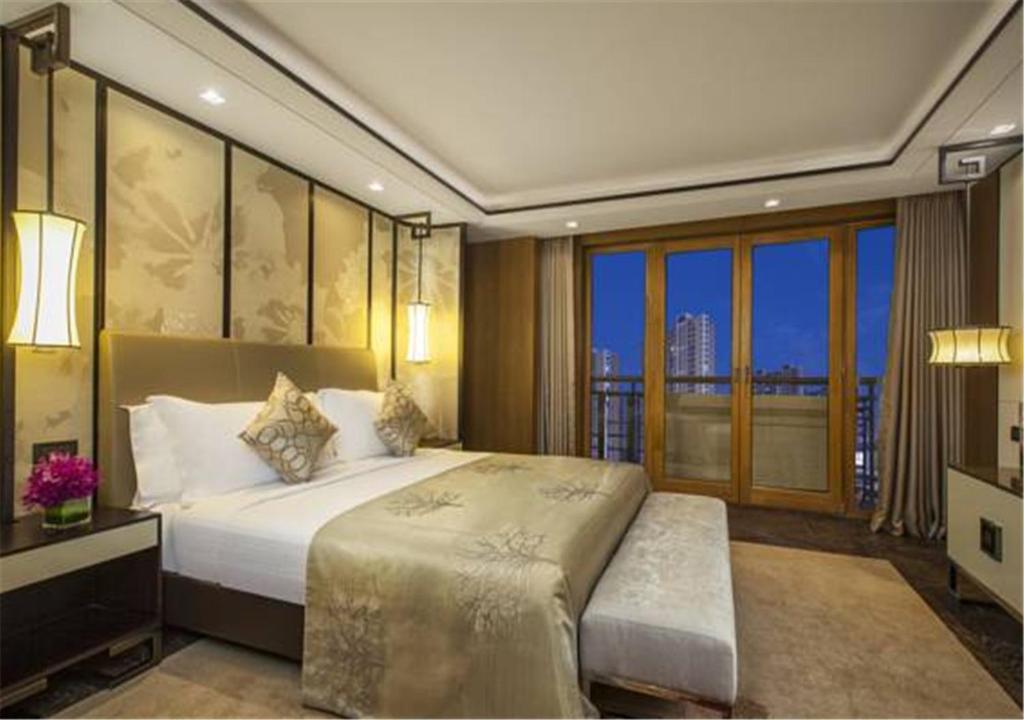 a bedroom with a large bed and a balcony at Ascott Riverside Garden Beijing in Beijing