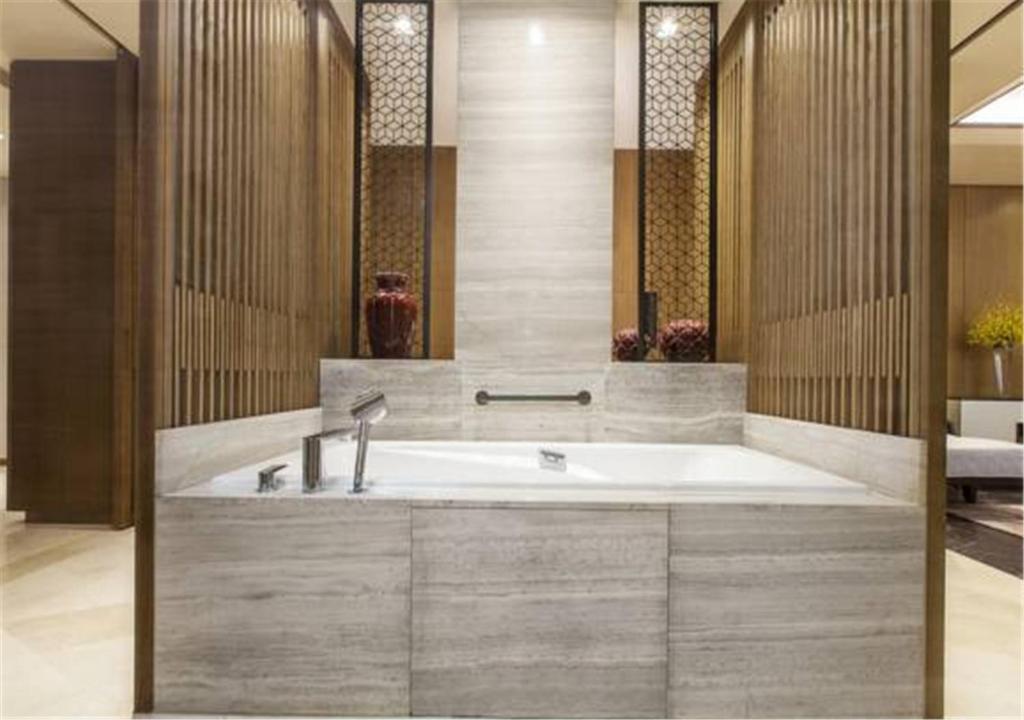 a bathroom with a bath tub with a sink at Ascott Riverside Garden Beijing in Beijing
