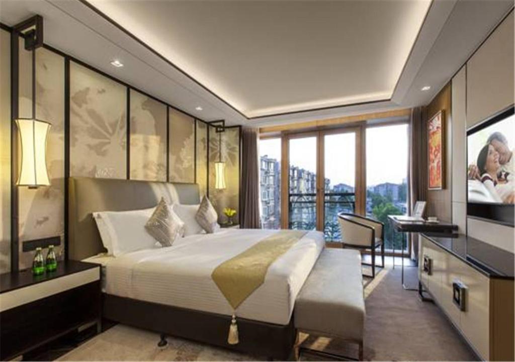 a bedroom with a large bed and a television at Ascott Riverside Garden Beijing in Beijing
