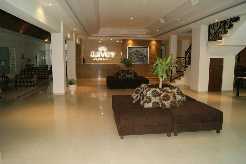 eine Lobby mit einer Couch und einer Palme darin in der Unterkunft Savoy Express in Torreón