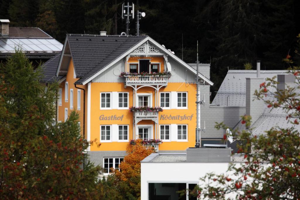 ein gelbes Gebäude mit Balkon darüber in der Unterkunft Ködnitzhof in Kals am Großglockner