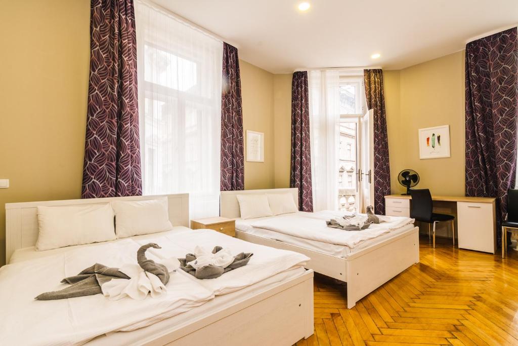 two beds in a room with swans on them at Centric Lifestyle Apartments in Budapest