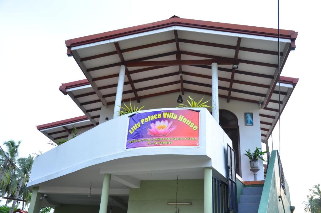 een gebouw met een bord ervoor bij Lilly Palace Villa Guest House in Negombo