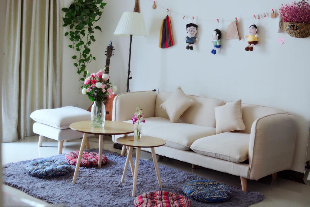 a living room with a couch and two tables at Lan House Youth Apartment in Guangzhou