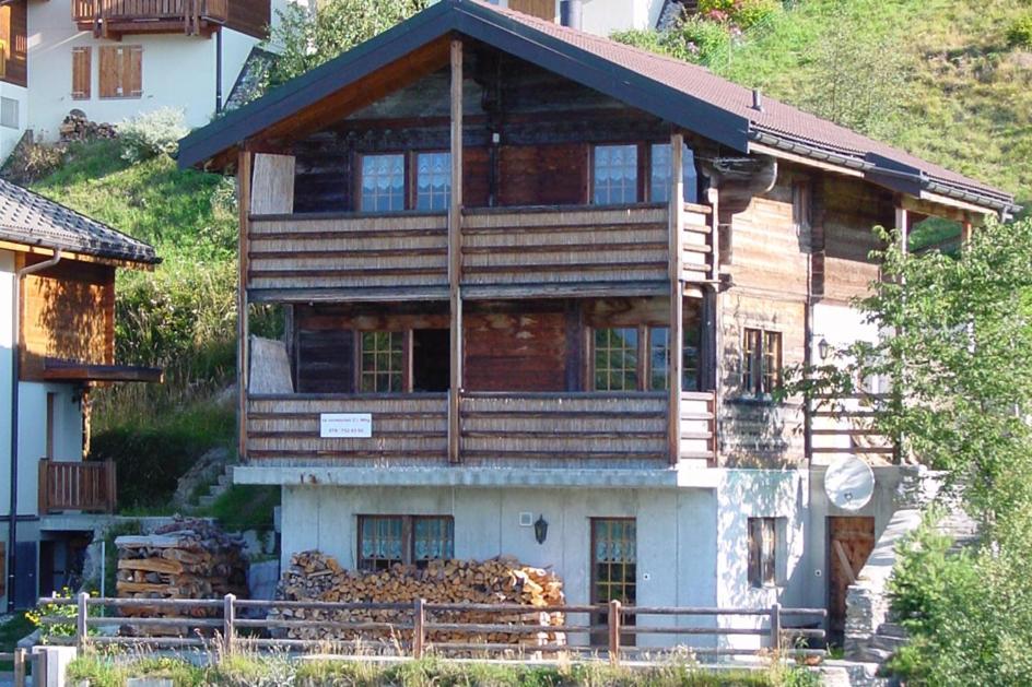 a large wooden house on the side of a hill at Alpenparadies in Gampel