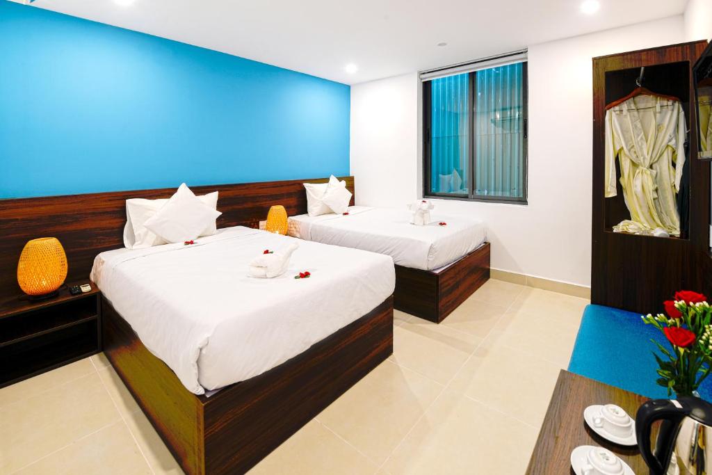 Postel nebo postele na pokoji v ubytování Hoi An Dream City Hotel
