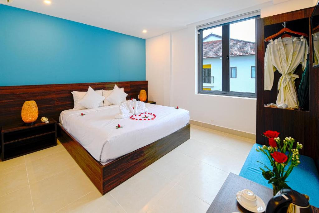 Un dormitorio con una cama y una mesa con velas. en Hoi An Dream City Hotel, en Hoi An