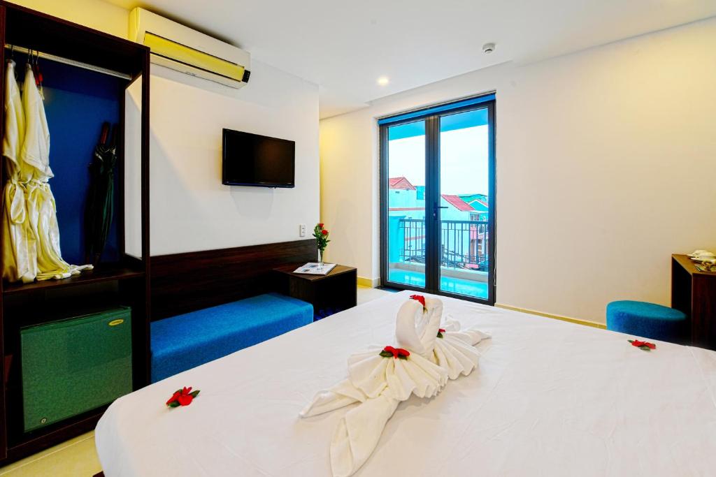 Postel nebo postele na pokoji v ubytování Hoi An Dream City Hotel