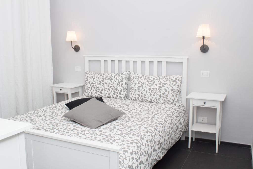 una camera bianca con un letto bianco e due tavoli bianchi di Residenza Spinelli a Napoli