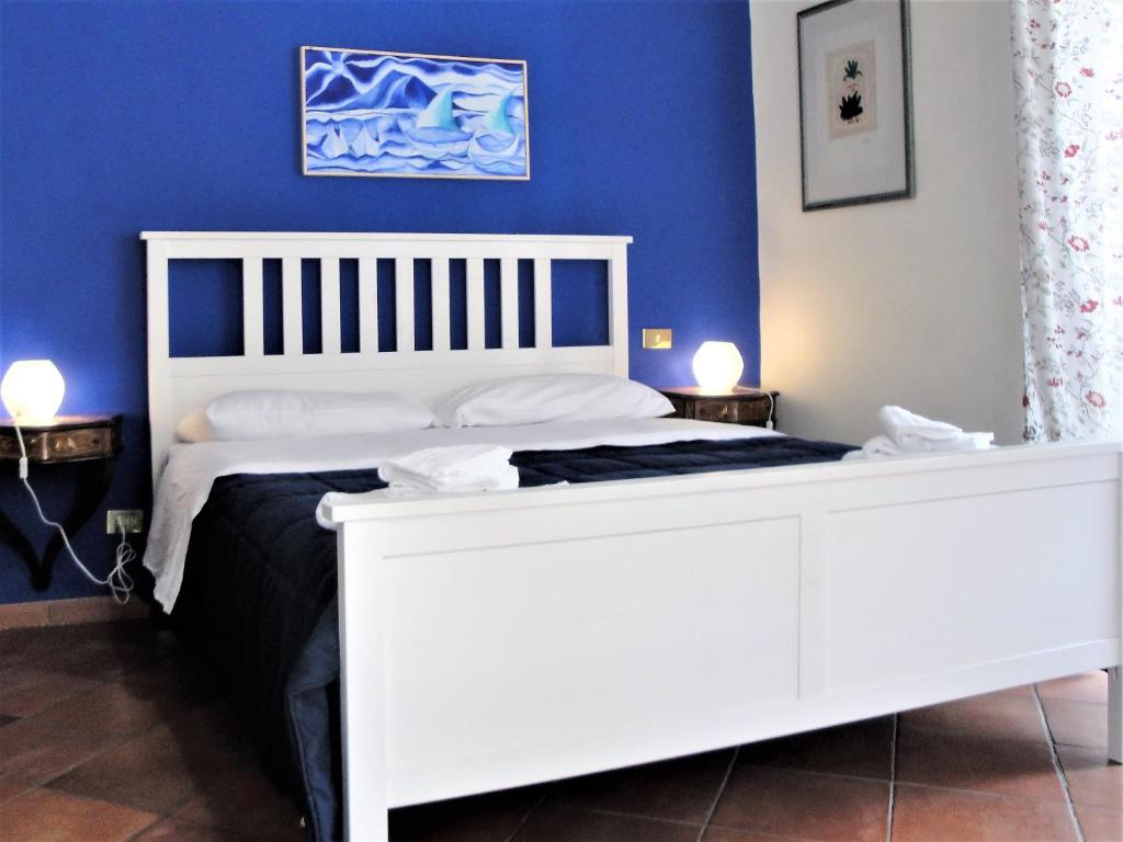 een wit bed in een kamer met een blauwe muur bij Umberto I Holiday House in Napels